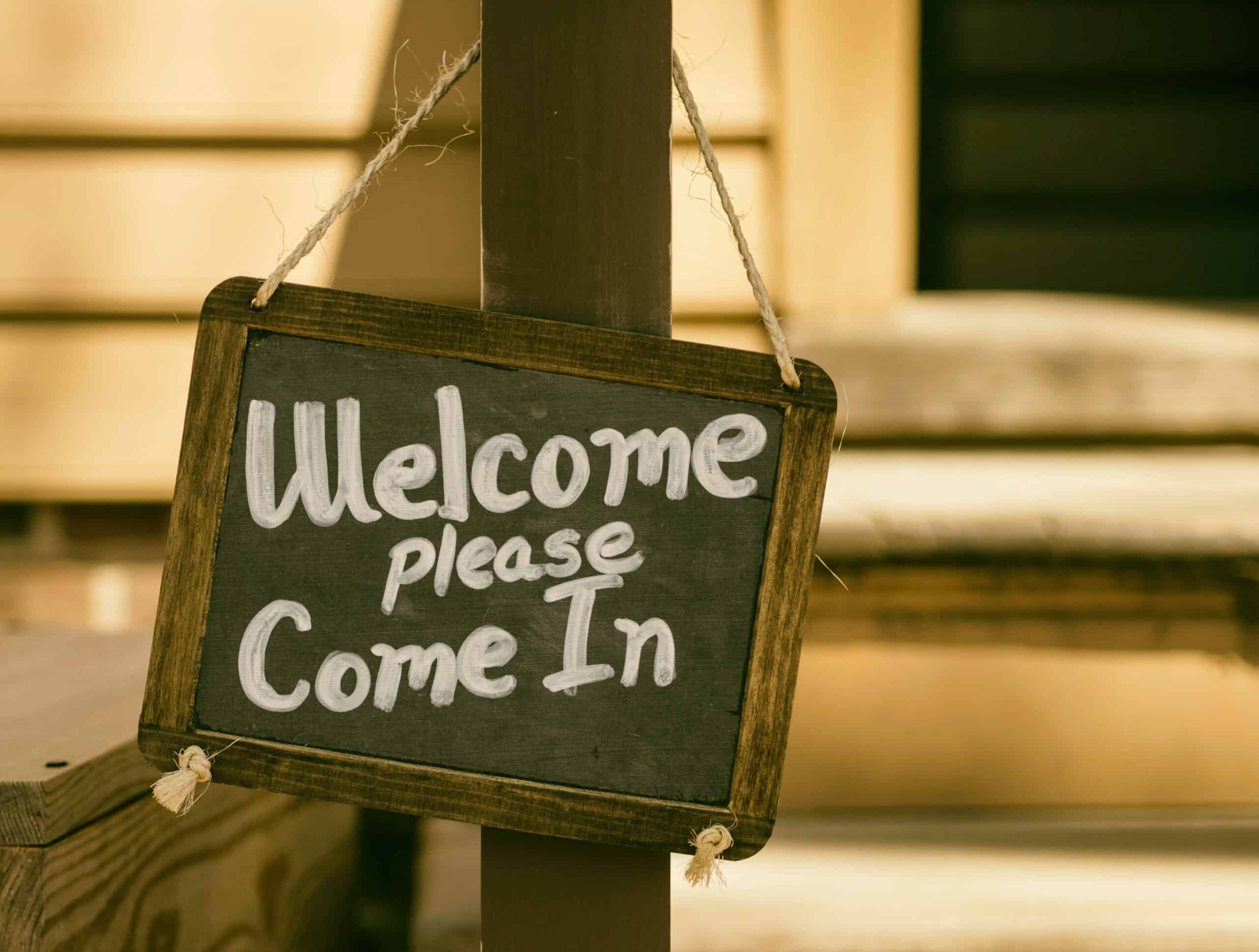 A chalk board sign that reads 'welcome please come in'